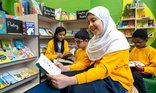 School children read books in their new primary school library