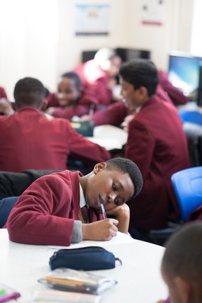 Boy writing in classroom