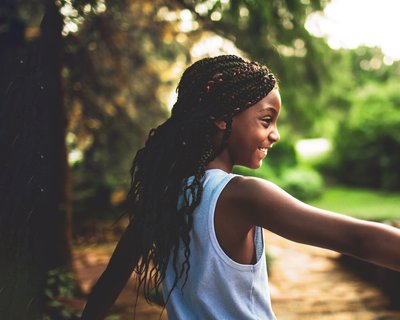 Child girl outside happy nature community - National Literacy Trust