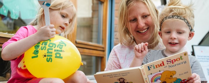 Family enjoy a story together at a National Literacy Trust summer literacy event