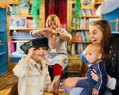 Lit Champ Janice sharing a story and song with families on board the Bradford Stories Bus
