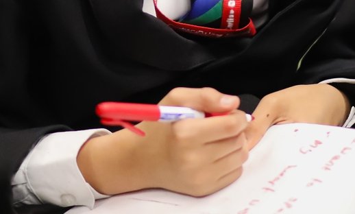 Close up of a student writing during a National Literacy Trust poetry workshop