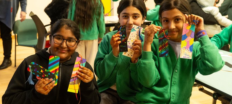 Children at a Raising Readers event show the bookmarks they decorated