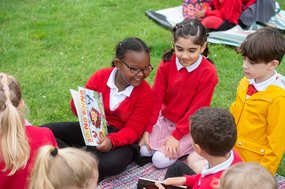 Primary children reading outdoors