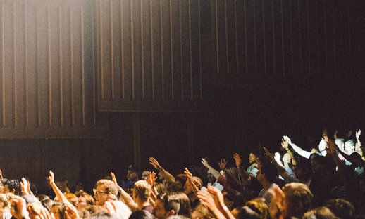 Seated crowd of children with hands raised School_National Literacy Trust