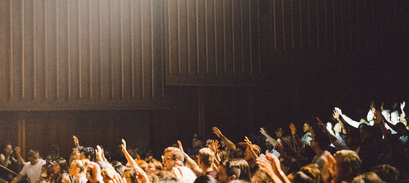 Seated crowd of children with hands raised School_National Literacy Trust