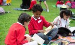 Children outside chatting about a book
