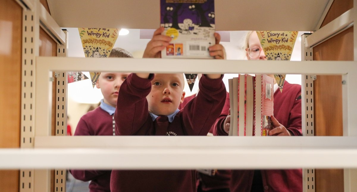 Children stack shelves as they create a new library display based on the Diary of a Wimpy Kid books at our Pupil Librarian Conference