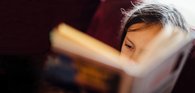 Close up of a young child reading a book