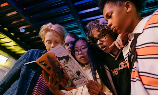 Young people look at comic book together