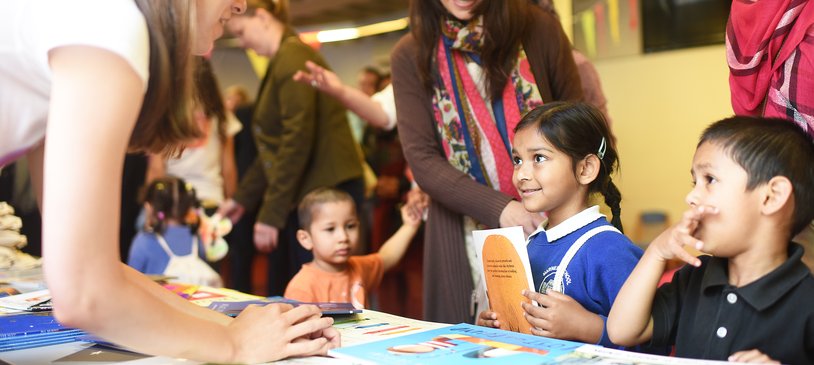 child in school uniform receiving book.jpg