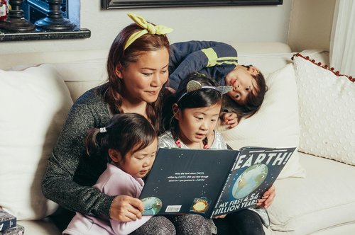 Mum reading with three children